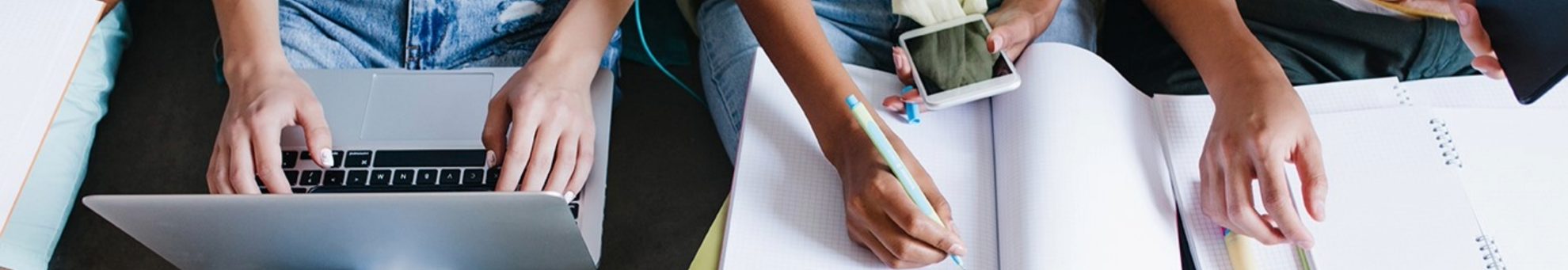 Personas estudiando con ordenadores, cuadernos y teléfonos