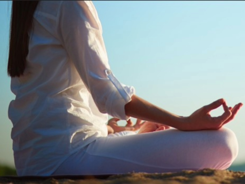 Mujer vestida de blanco meditando en calma