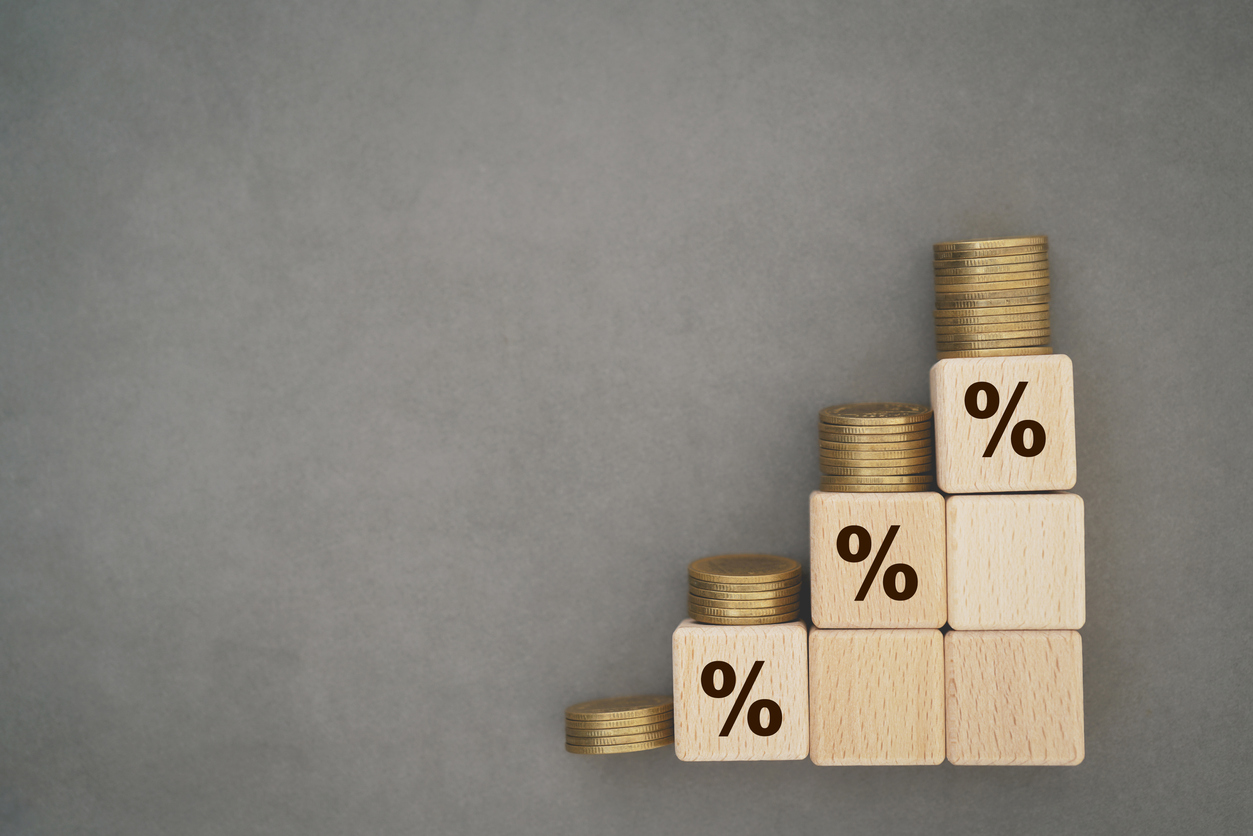 Wooden cube blocks with percentage sign and stack of coins. For  financial and business growth interest rates and mortgage rates interest on investment inflation concept on grunge grey background