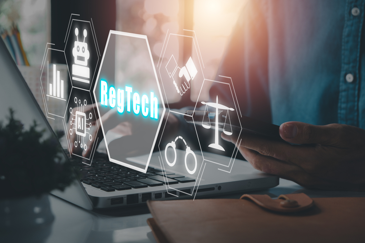 RegTech, Regulation Compliance financial control modern internet technology concept, Person working on laptop computer with RegTech icon on virtual screen.